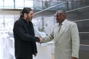 Lior Frenkel, CEO and Co-Founder at Waterfall and Eddy Thésée, Vice President Cybersecurity at Alstom shaking hands in an office building lobby.